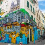 building in Marseille that is completely covered in street art featuring an orange grinning cat