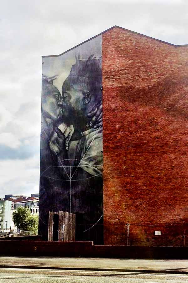 street art in Manchester by Faith47 of two men kissing