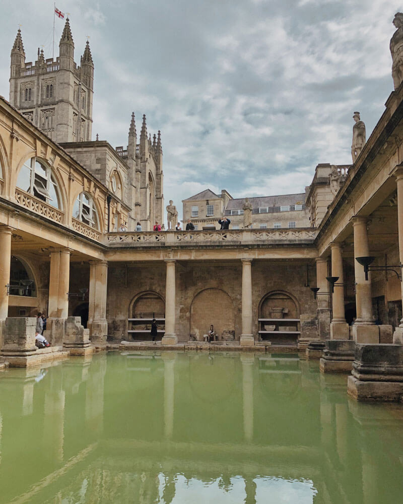 the outdoors Great Bath with its green-hued water in the Roman Baths is one of the top attraction in Bath, England